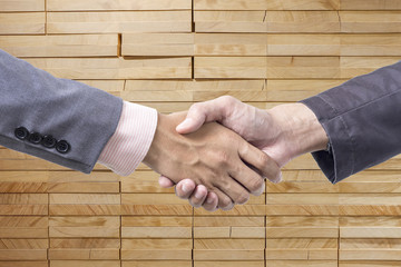 Business handshake on wood background