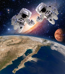 Two astronauts spaceman planet spacewalk outer space walk moon mars galaxy. Elements of this image furnished by NASA.