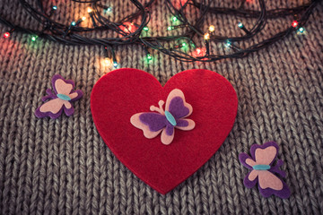 Red felt heart, colorful garland with woollen texture in the bac