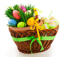 Wicker wooden basket with Easter eggs and fresh grass