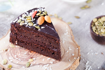 Vegan chocolate beet cake with avocado frosting, decorated with nuts and seeds