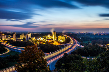 Obraz premium Leuchtspuren von Autos auf der Autobahn A60 bei Mainz an einer Fabrik