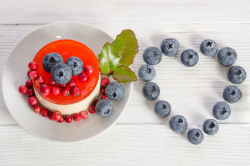 Frame- heart from blueberry  and fruitcake on wooden table   top