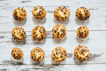 Muffins set in rows on wooden table 