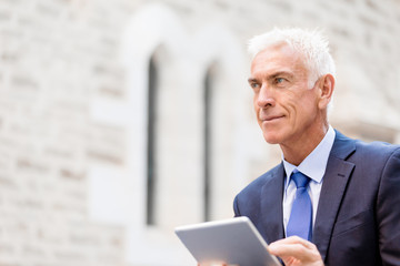 Senior businessman holding touchpad 