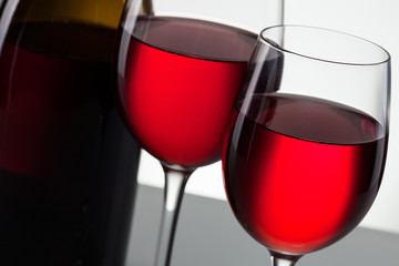 Glass of wine and bottle on white with copy space