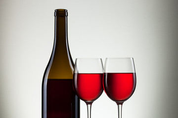 Glass of wine and bottle on white with copy space