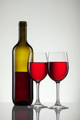 Glass of wine and bottle on white with copy space