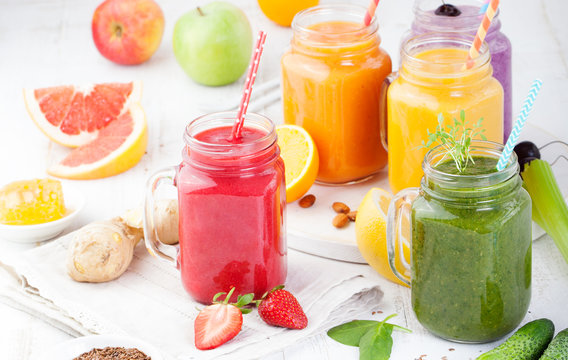 Smoothies, juices, beverages, drinks variety with fresh fruits and berries on a white wooden background