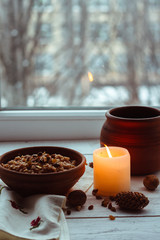 Christmas porridge with candles on white wooden background