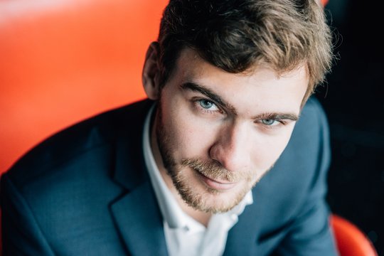 Portrait Of Young Business Man Seated On A Red Chair