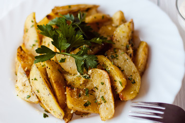 beautiful roasted potatoes with herbs and spices on a white plate