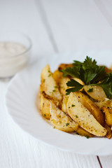 beautiful roasted potatoes with herbs and spices on a white plate