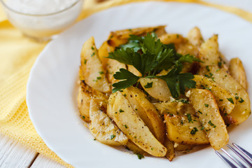 beautiful roasted potatoes with herbs and spices on a white plate