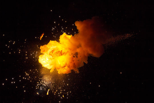 Realistic fiery explosion busting over a black background