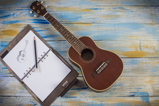 Ukulele with notebook and pencil