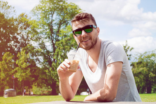 Handsome man drinking coffee in park
