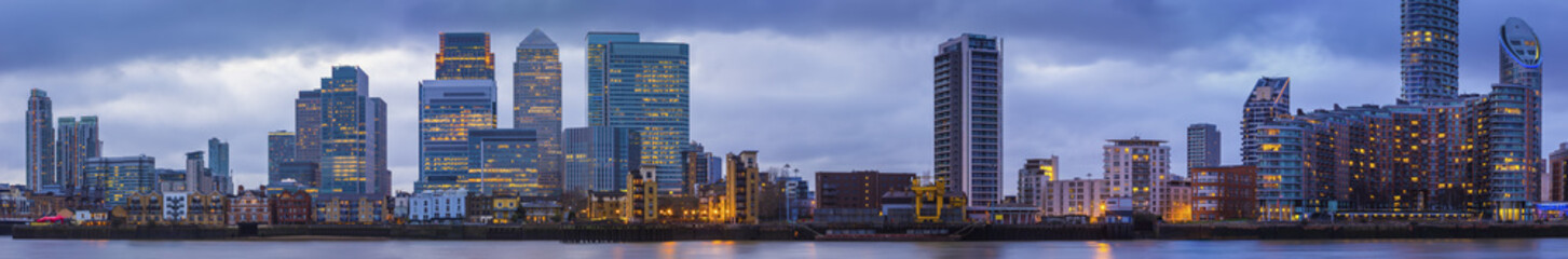 Wide panoramic skyline of Canary Wharf, the worlds leading financial district at blue hour -...