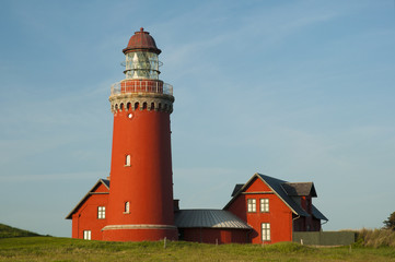 Fototapeta na wymiar beautiful red Lighthouse Bovbjerg Fyr with green grass and blue sky, Danish North Sea coast, Jutland, Denmark, Europe 