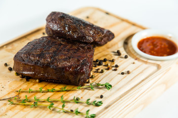Beautiful juicy well done steak with sauce on a wooden Board