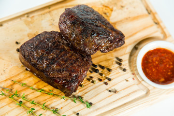 Beautiful juicy well done steak with sauce on a wooden Board