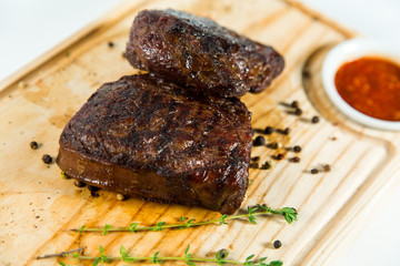 Beautiful juicy well done steak with sauce on a wooden Board