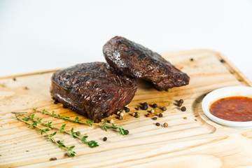 Beautiful juicy well done steak with sauce on a wooden Board