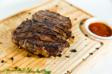 Beautiful juicy well done steak with sauce on a wooden Board