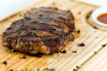 Beautiful juicy well done steak with sauce on a wooden Board