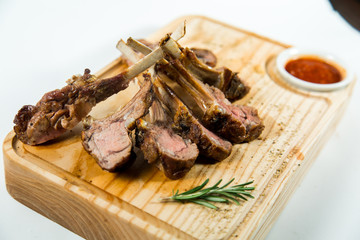 Close up view of Beautiful juicy barbecue ribs with sauce on a old wooden board