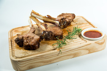 Close up view of Beautiful juicy barbecue ribs with sauce on a old wooden board