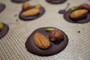 Making dark chocolate mendiants candies with nuts