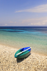 Fototapeta na wymiar Canoe and kayak on pebble beach, Monodendri beach, Paxos island, Greece. 