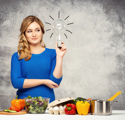 Young and beautiful housewife woman cooking in a kitchen