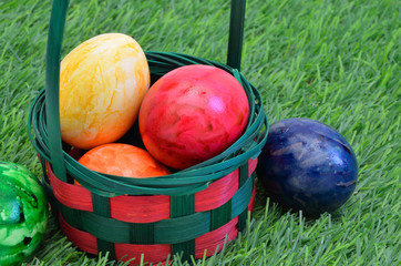 Bunte Ostereier / bunte Ostereier in einem Korb auf dem Rasen, Nahaufnahme, Makro, Querformat, horizontal