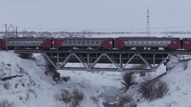 Electric train in movement on bridge in winter