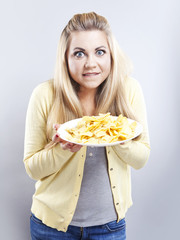Young girl with potato chips. She thinks. Blonde watch your diet
