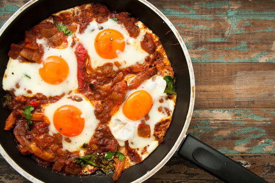 Shakshuka, a dish of eggs poached in a sauce of tomatoes, chili peppers, and onions, spiced with cumin. This recipe includes swiss chard leaves. Tunisian origin but is also very popular in Israel.