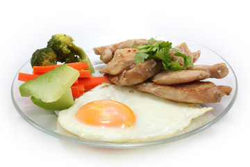 Grilled chicken steaks with egg and vetgetables on white background