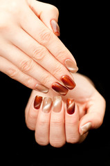 brown pearl manicure style cat eyes on a black background