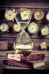 Vintage hourglass on the old books