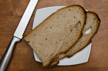 slices of bread / pieces of bread on a plate and bread knife