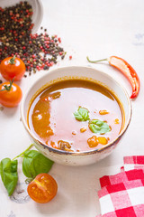 Tomato soup with meat in a white bowl on a white wooden backgrou