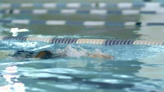 Close-up shot of Professional Female Swimmer Performing Front Crawl during Training in Swimming Pool. Shot on RED Cinema Camera.