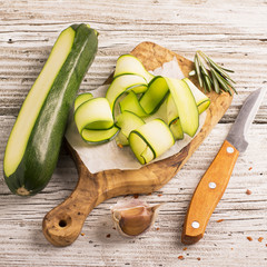 Thin slices of zucchini on olive board