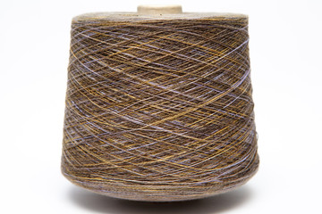 The cone of colored wool thread on a white background