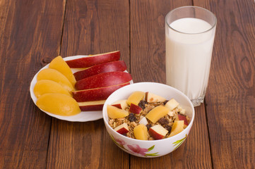 muesli with peach, apple and a glass of milk