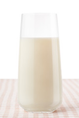 Glass of milk on classic brown and white checkered tablecloth