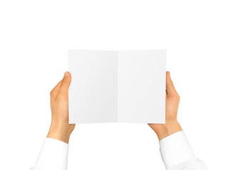 Hand in white shirt sleeve holding blank booklet card in the hand.