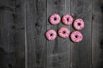 Różowe pączki na drewnianym tle
